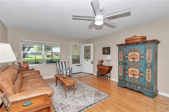 8787 SW 90th Ln Unit E, Ocala, FL 34481 - living area with a textured ceiling, wood finished floors, baseboards, and a ceiling fan