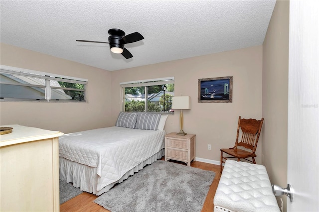 8787 SW 90th Ln Unit E, Ocala, FL 34481 - bedroom featuring ceiling fan, light wood-type flooring, baseboards, and a textured ceiling