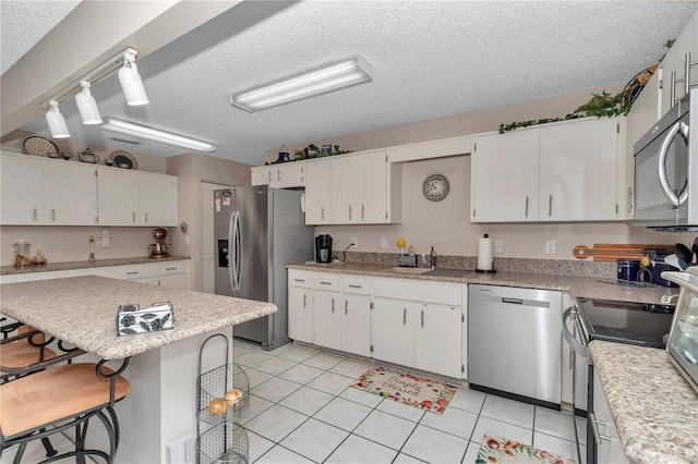 8787 SW 90th Ln Unit E, Ocala, FL 34481 - kitchen with a sink, light countertops, appliances with stainless steel finishes, and a breakfast bar