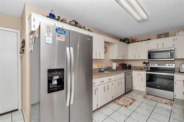 8787 SW 90th Ln Unit E, Ocala, FL 34481 - kitchen with light tile patterned floors, a textured ceiling, light countertops, appliances with stainless steel finishes, and a sink