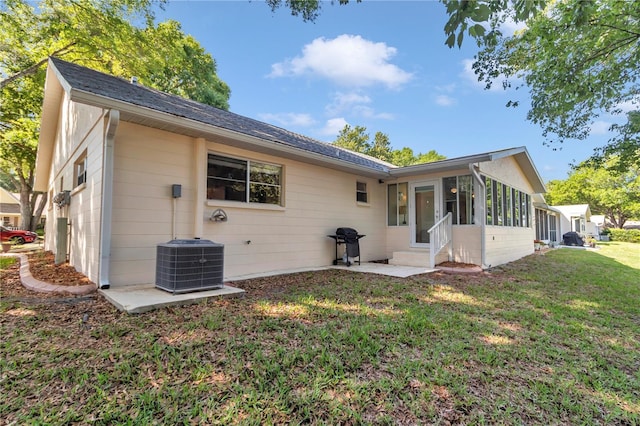 8787 SW 90th Ln Unit E, Ocala, FL 34481 - back of property with central AC unit, a sunroom, and a lawn