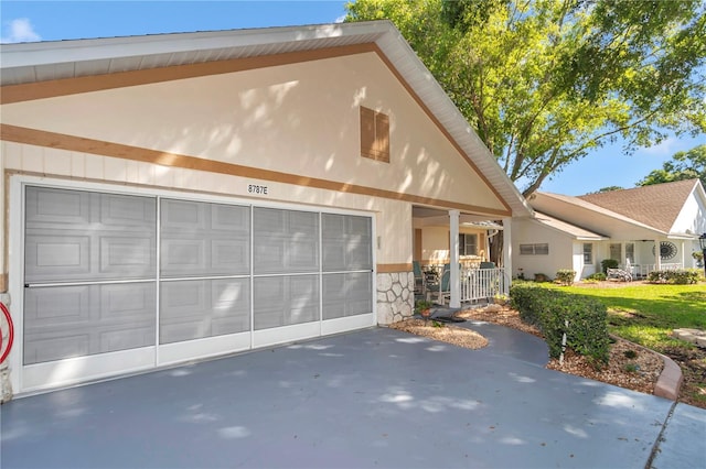 8787 SW 90th Ln Unit E, Ocala, FL 34481 - view of front of home with a garage, stucco siding, and stone siding