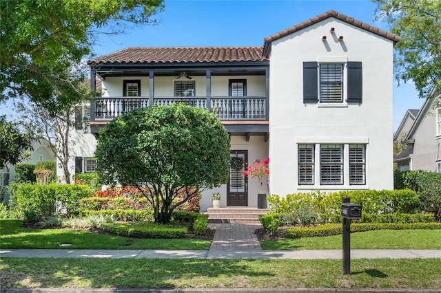 mediterranean / spanish-style house with stucco siding, a tiled roof, and a balcony