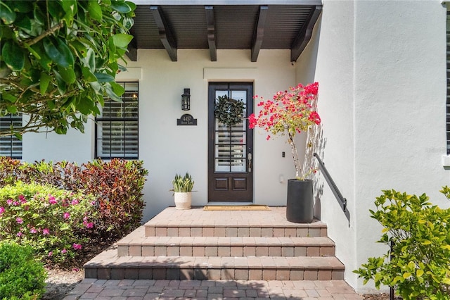 property entrance with stucco siding