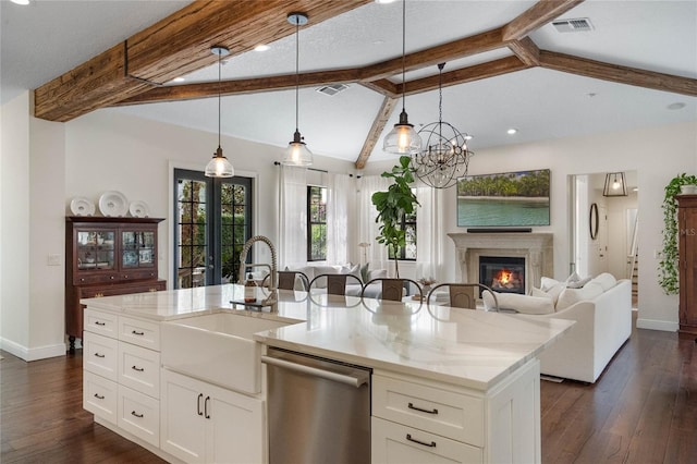 kitchen featuring a glass covered fireplace, visible vents, vaulted ceiling with beams, a sink, and stainless steel dishwasher