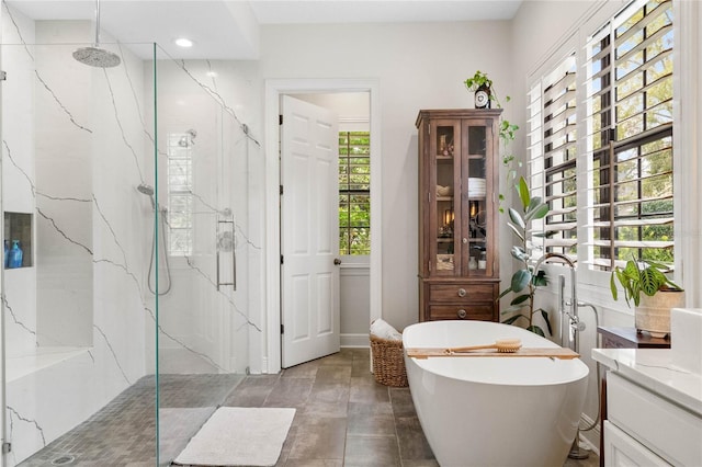 full bathroom featuring vanity, a soaking tub, and a marble finish shower