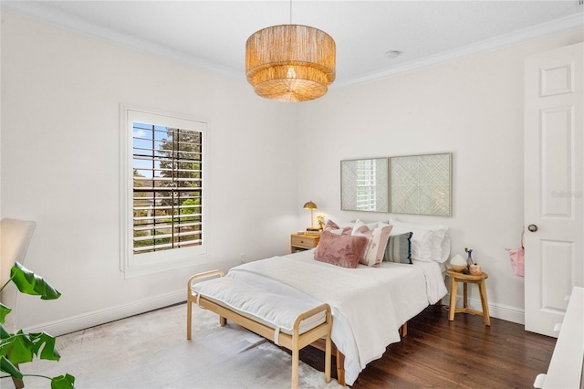 bedroom with baseboards, wood finished floors, and crown molding