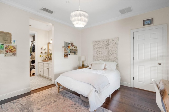 bedroom with a chandelier, visible vents, a walk in closet, and wood finished floors