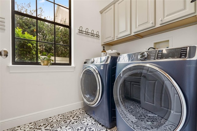 laundry room featuring tile patterned flooring, washing machine and dryer, cabinet space, and baseboards