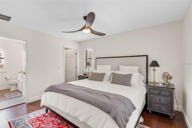 bedroom featuring visible vents, dark wood-type flooring, and baseboards