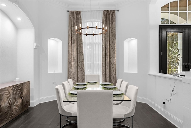 dining space with crown molding, a notable chandelier, wood finished floors, and baseboards