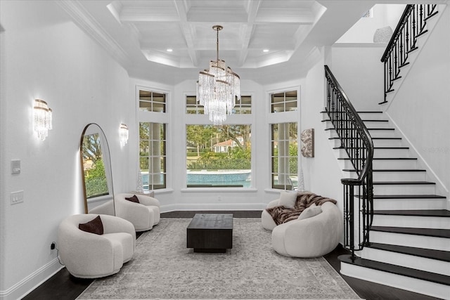 living room with beam ceiling, a notable chandelier, a towering ceiling, and stairs