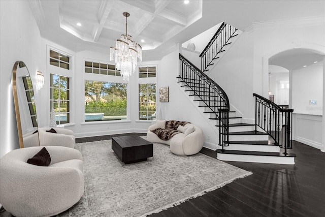 living area with stairway, coffered ceiling, a high ceiling, dark wood-style flooring, and ornamental molding