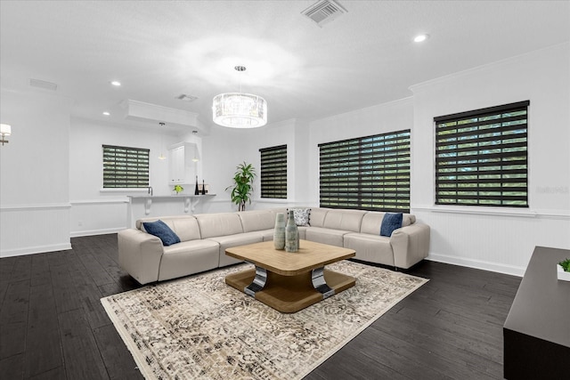 living room with visible vents, a notable chandelier, a wainscoted wall, and dark wood-style flooring