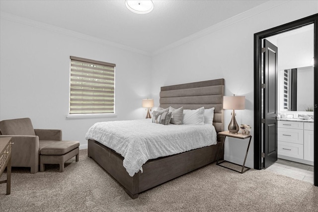 bedroom featuring light colored carpet, ornamental molding, and ensuite bathroom