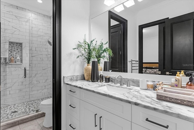 bathroom with tile patterned flooring, a shower stall, toilet, and vanity