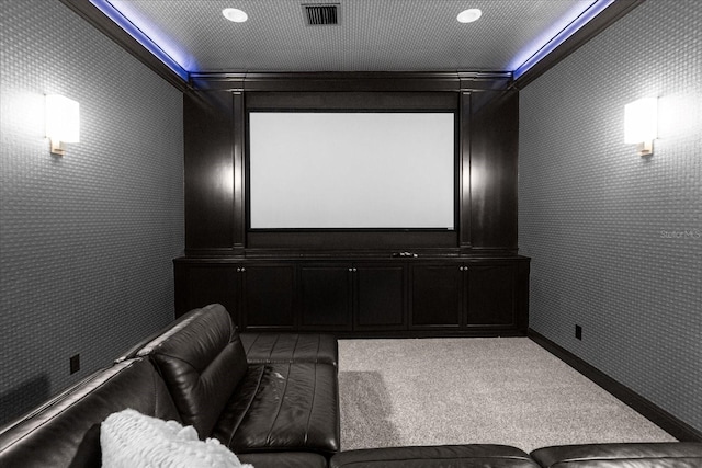 carpeted home theater room with visible vents and wallpapered walls