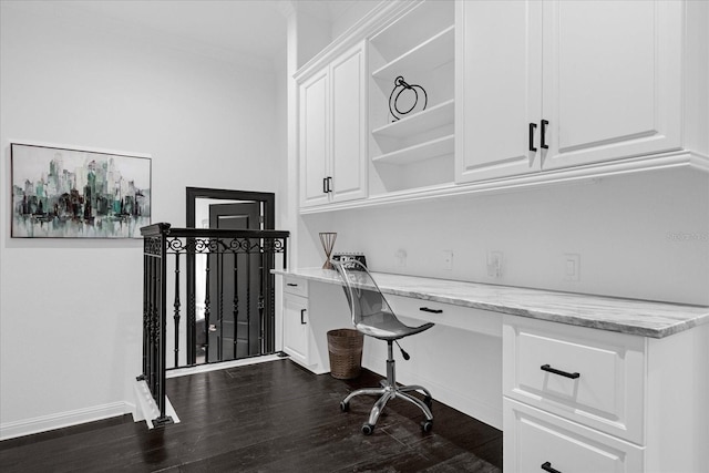 home office with dark wood finished floors, built in study area, baseboards, and ornamental molding