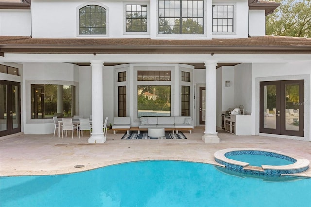 view of pool with a patio, area for grilling, french doors, and a pool with connected hot tub