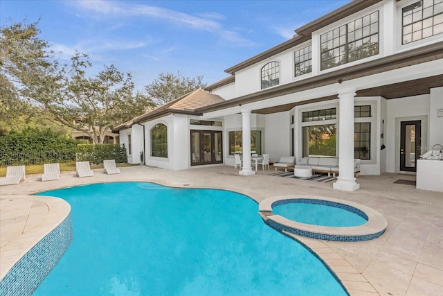 view of pool with a patio, french doors, and a pool with connected hot tub