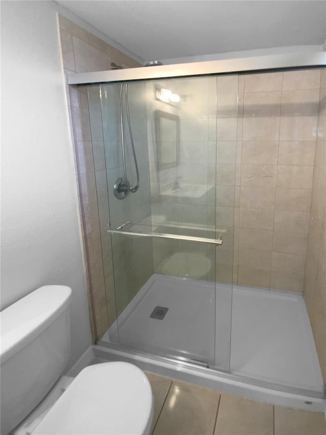 bathroom featuring toilet and a stall shower