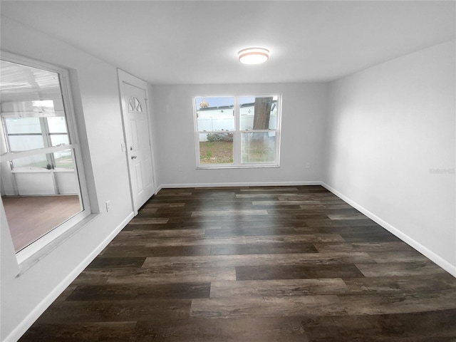 spare room featuring dark wood finished floors and baseboards