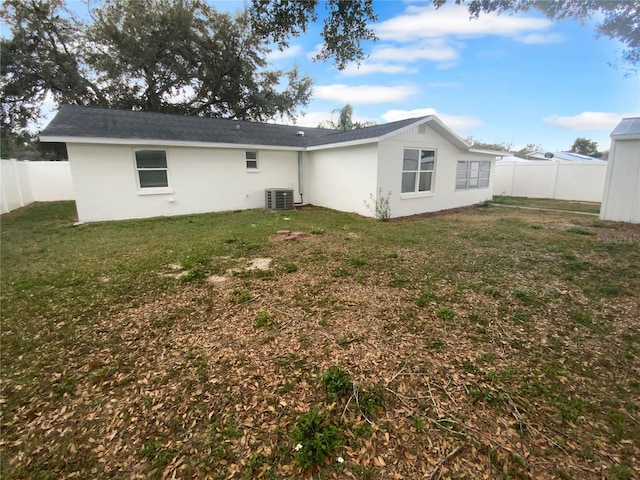 back of house featuring cooling unit, a lawn, and a fenced backyard