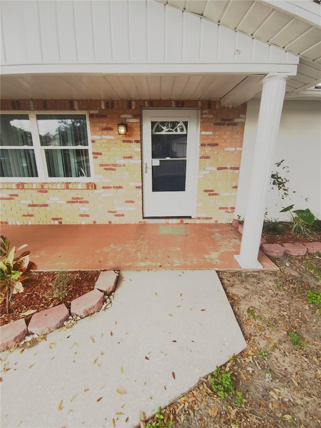 property entrance with brick siding and board and batten siding