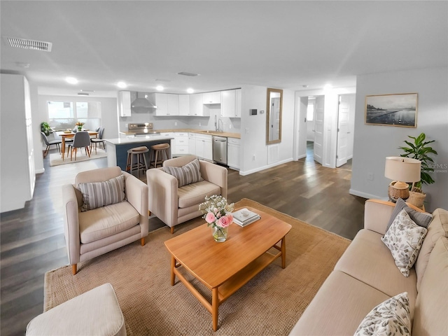 living room with visible vents, baseboards, and dark wood-style flooring