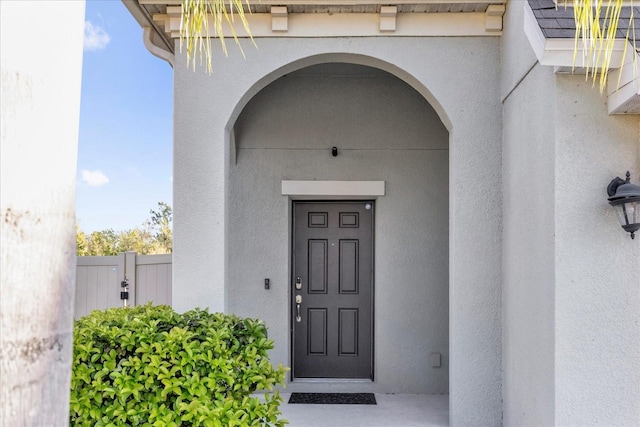 entrance to property featuring stucco siding