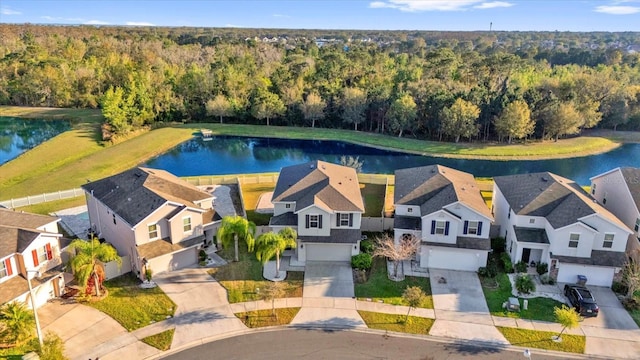 aerial view featuring a residential view, a forest view, and a water view