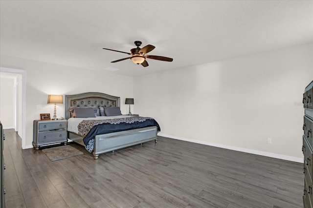 bedroom with a ceiling fan, baseboards, and wood finished floors