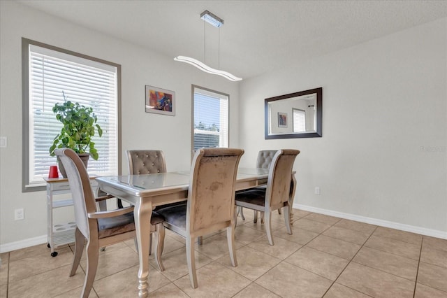 dining room with light tile patterned floors and baseboards