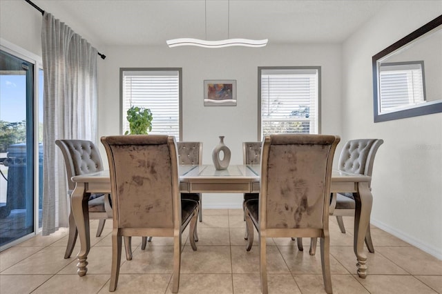 dining space featuring baseboards, a healthy amount of sunlight, and light tile patterned flooring