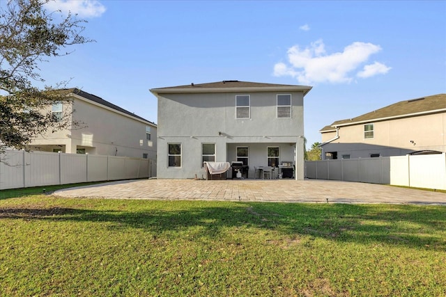 back of property with a patio, fence, and a lawn