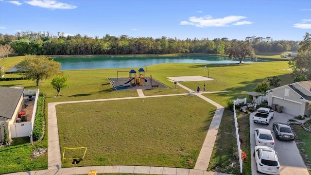 exterior space with a lawn, playground community, and a water view