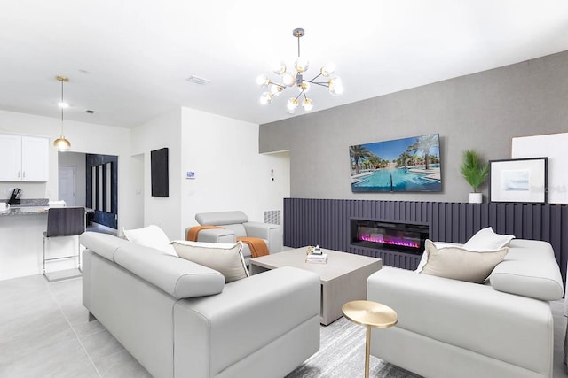 living area featuring a chandelier, visible vents, and a glass covered fireplace