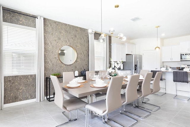 dining space featuring light tile patterned floors, visible vents, wallpapered walls, and baseboards