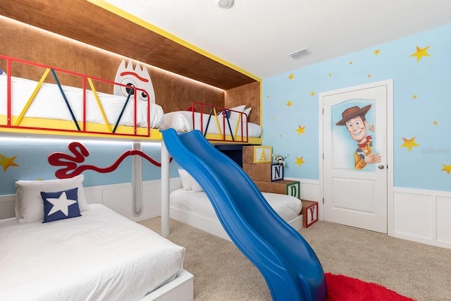 bedroom with visible vents, a wainscoted wall, and carpet flooring