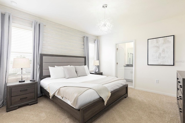 bedroom featuring baseboards, light carpet, a notable chandelier, and connected bathroom