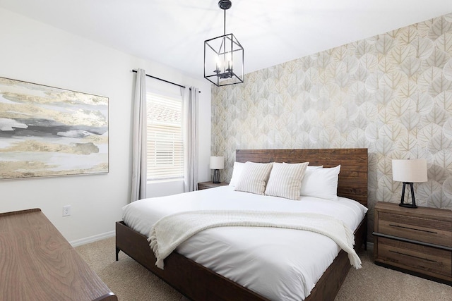 carpeted bedroom with baseboards, a notable chandelier, and wallpapered walls