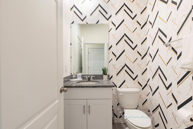 bathroom with vanity, tile walls, and toilet