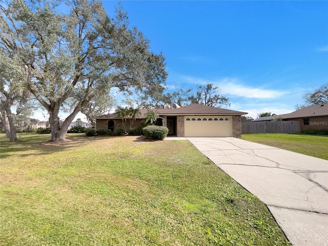 ranch-style home featuring brick siding, an attached garage, driveway, and a front lawn