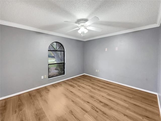 empty room with wood finished floors, ceiling fan, and ornamental molding