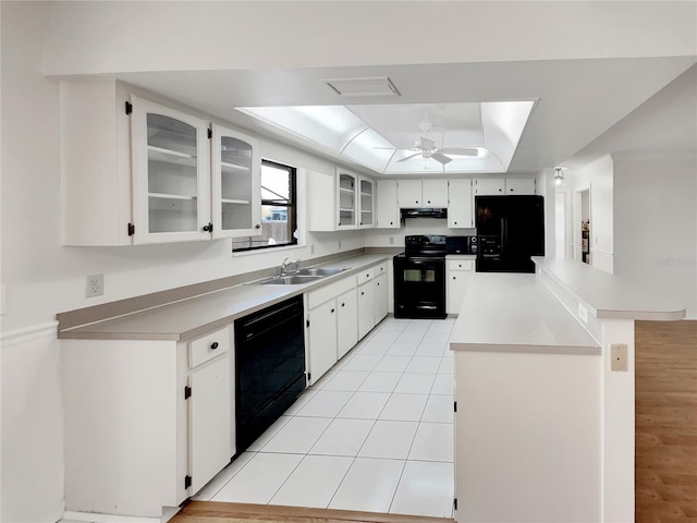 kitchen with visible vents, ceiling fan, black appliances, a raised ceiling, and a sink