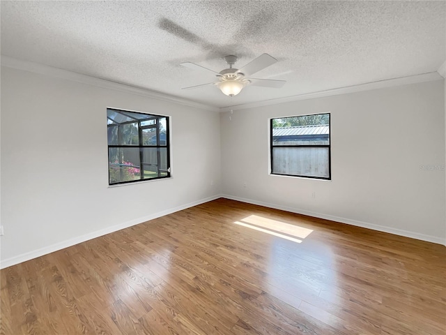 spare room with ornamental molding, baseboards, and wood finished floors