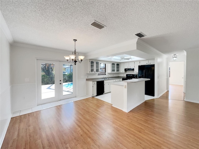 kitchen featuring visible vents, light wood-style floors, black appliances, and a center island