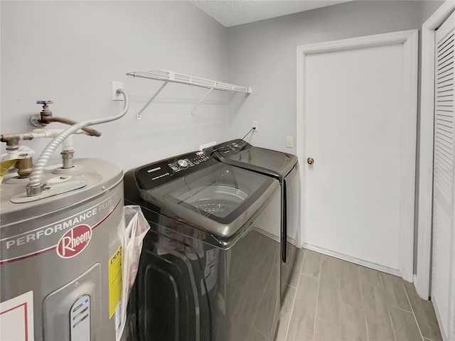 laundry room featuring laundry area, separate washer and dryer, water heater, and wood tiled floor