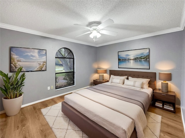 bedroom featuring crown molding, wood finished floors, baseboards, and a textured ceiling