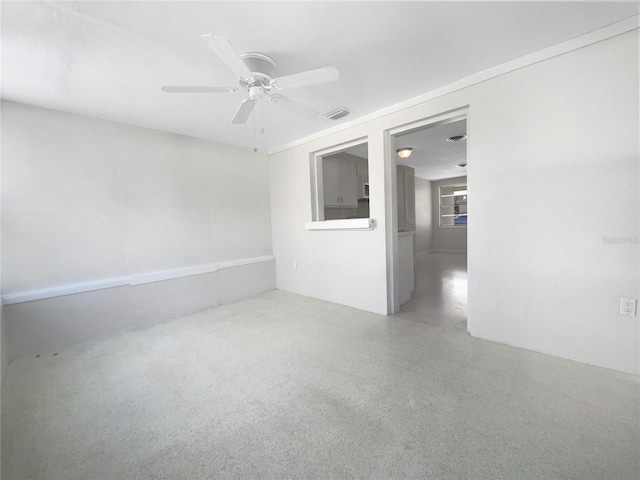 unfurnished room featuring a ceiling fan and speckled floor